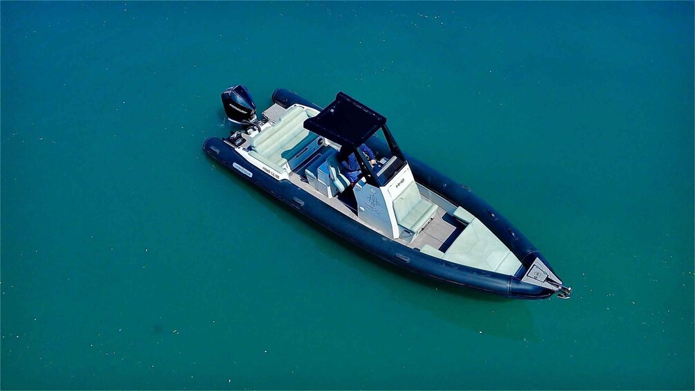 A small motorboat with a cabin and seating area, floating on calm water. 5
