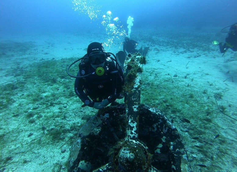Two scuba divers exploring an underwater wreck. 4