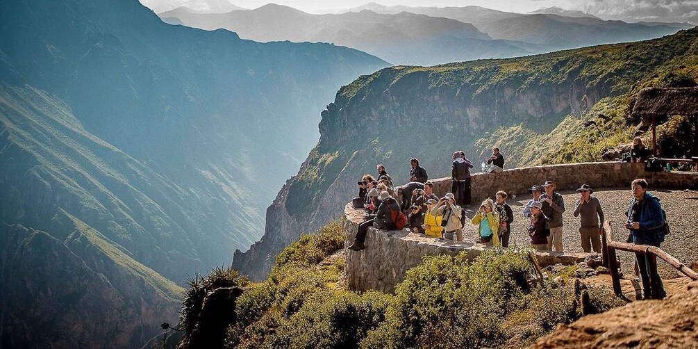 Un grupo de personas en la cima de una montaña, con vista a un valle profundo. 3