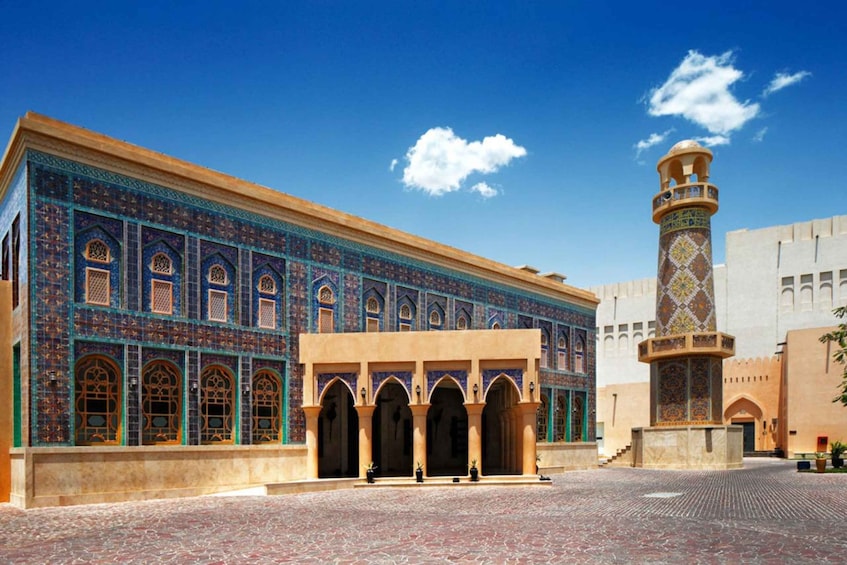 A historic building with intricate tile work and a minaret. 4