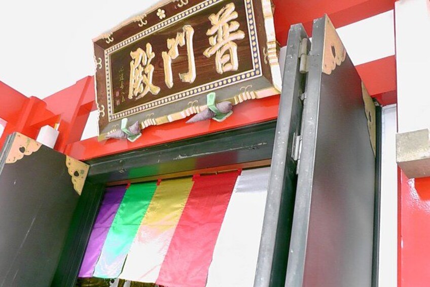 A storefront with a sign in Chinese characters and a rainbow-colored awning. 4