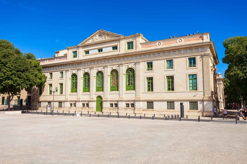 A large classical building with green windows and a central entrance. 3