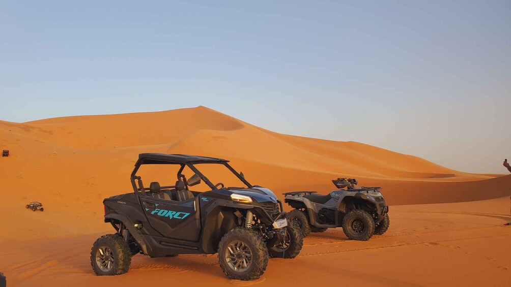 Two off-road vehicles in a desert with sand dunes. 4