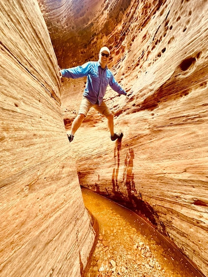 A person jumping in a narrow canyon with rock formations. 3