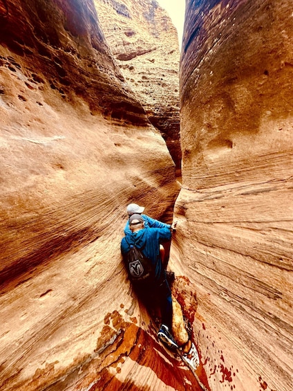 A person climbing a narrow canyon with steep walls. 4