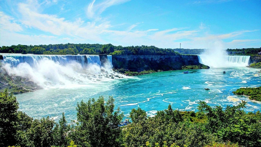 A large waterfall with multiple cascades, clear blue water, and surrounding greenery. 2