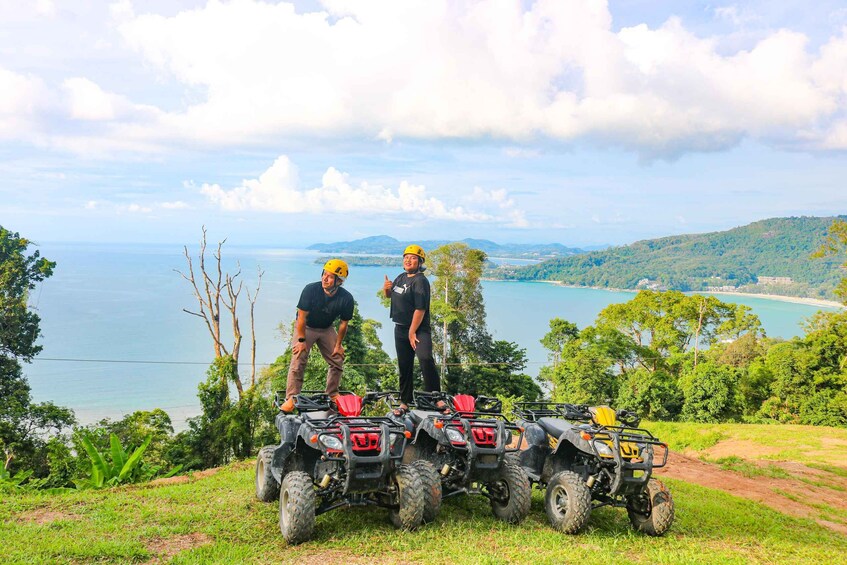 Two people on ATVs with a scenic coastal landscape in the background. 2