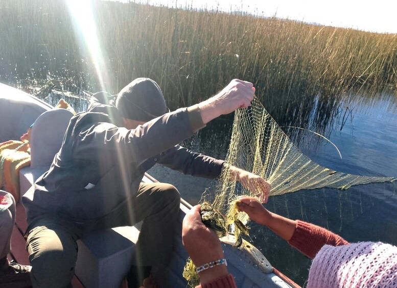 Una persona lanzando una red de pesca al agua. 2