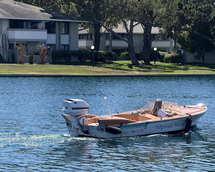 A boat named Edgewater Marine on calm water with a building and trees in the background. 3
