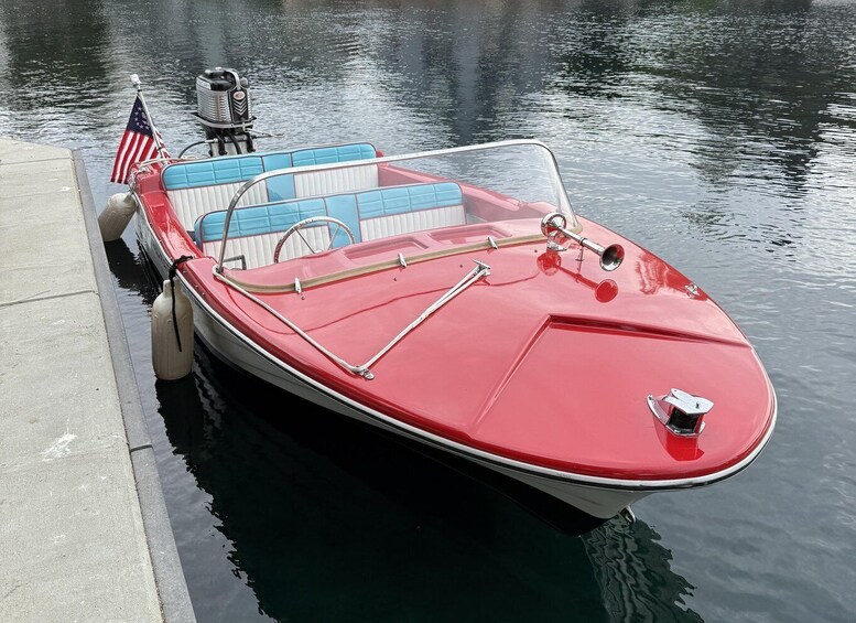 A red motorboat docked at a pier with an American flag. 4