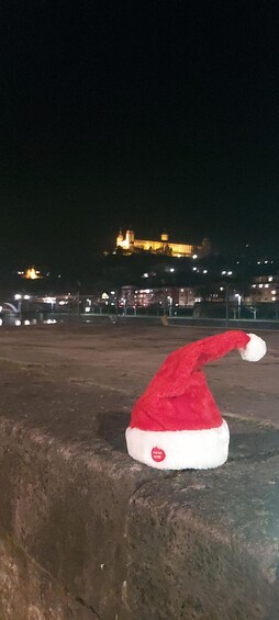 En rød julehat på en betonoverflade med et slot i baggrunden. 3