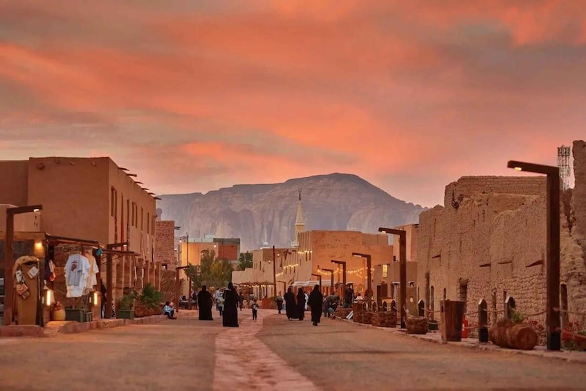 A street scene with buildings, a mosque, and mountains in the background. 3