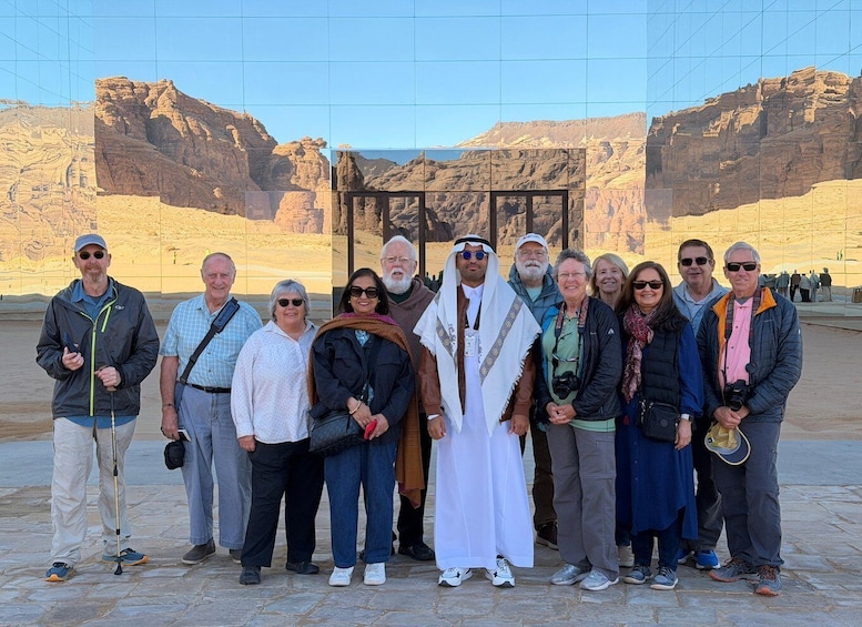 A group of people standing in front of a desert landscape with rocky formations. 5