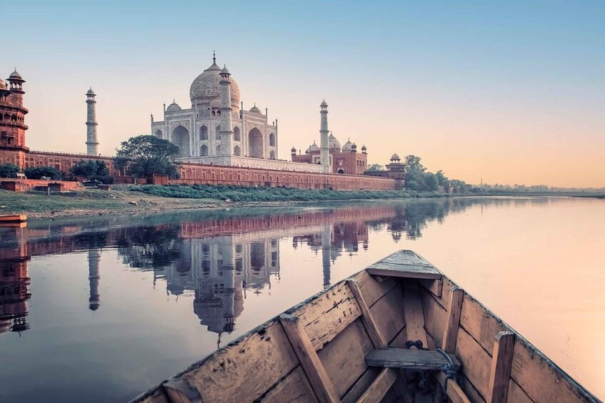 Taj Mahal, speglad i vattnet, med en båt i förgrunden och den omgivande mogularkitekturen. 4