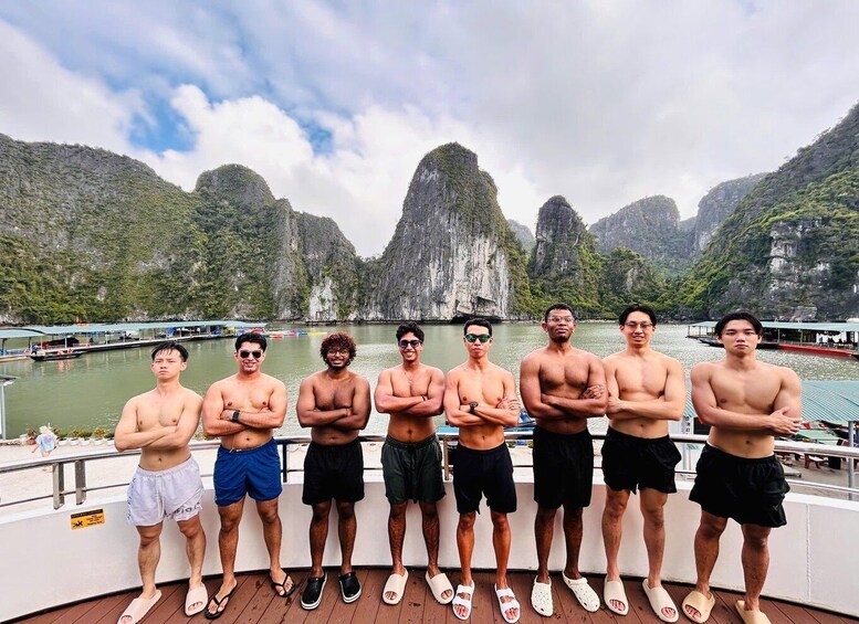 A group of people standing on a boat with a mountainous landscape in the background. 3