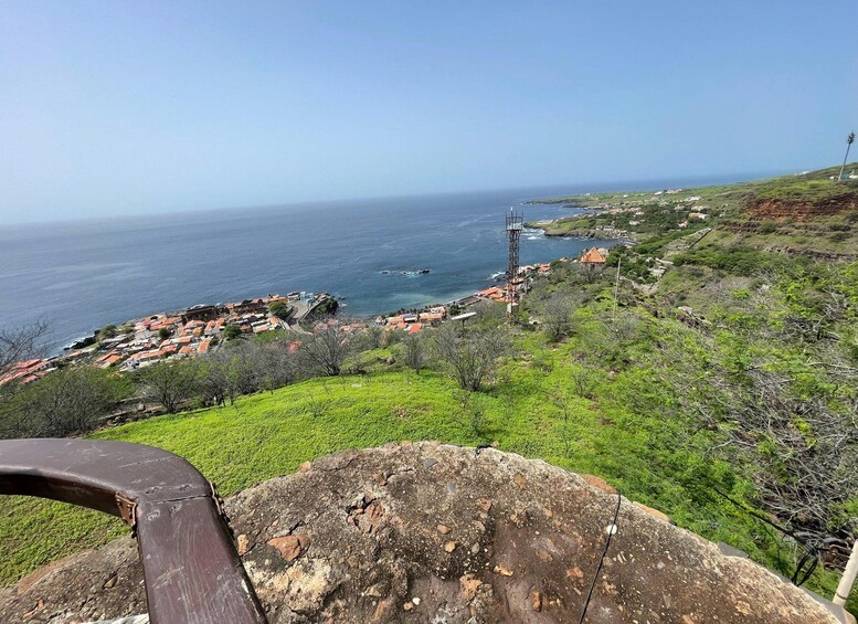 Un pueblo costero con un faro destacado, abundante vegetación y una vista despejada del océano. 2