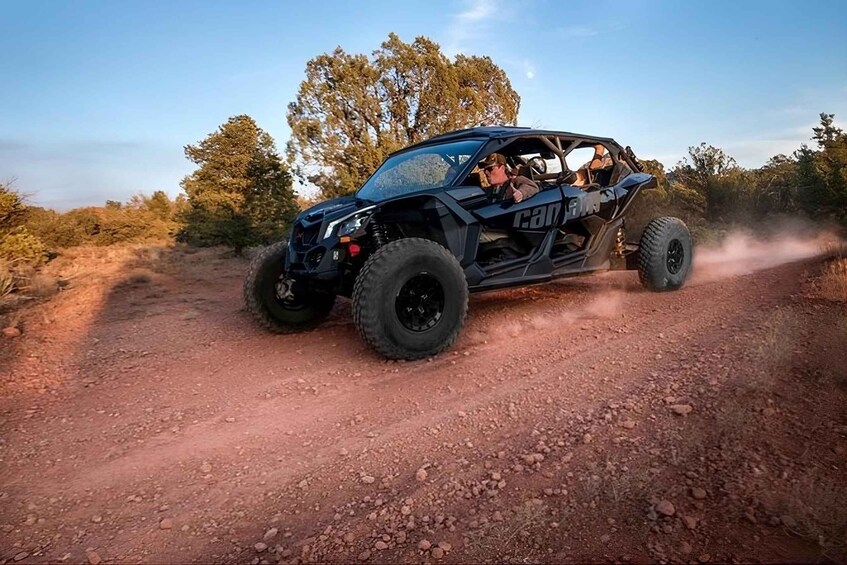 A black off-road vehicle on a dirt road with trees in the background. 3