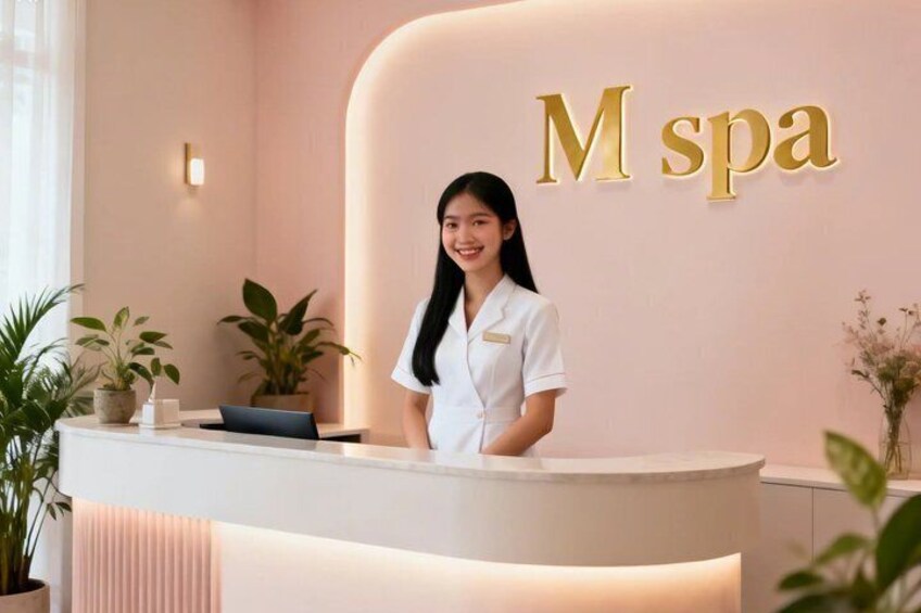 A reception desk with a sign that reads 'M spa' in gold letters, a receptionist in white uniform, and potted plants around the area. 1