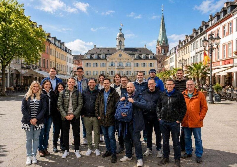 A group of people standing in a square with historic buildings and a church in the background. 5