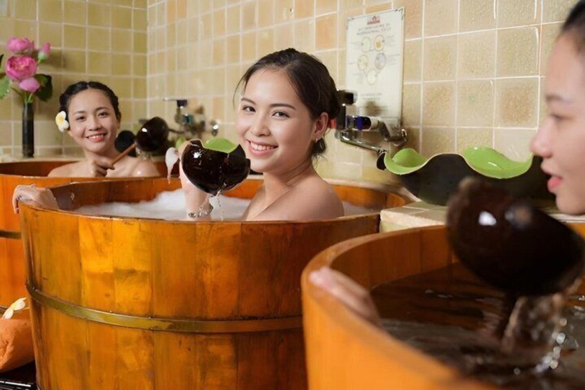 A group of people in wooden tubs in a spa setting. 3