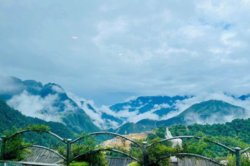 A mountainous landscape with a bridge and a statue. 2
