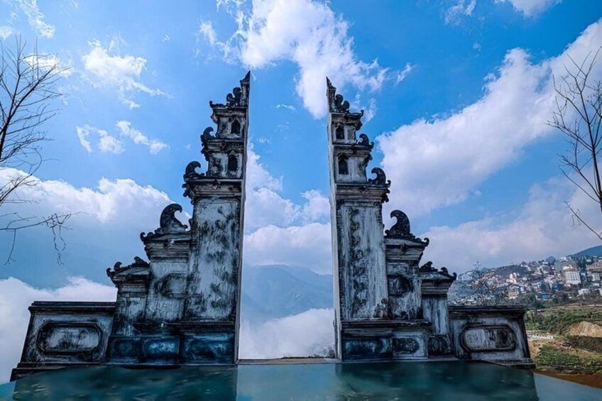 A historic gate with intricate carvings, set against a backdrop of a clear sky and distant mountains. 4
