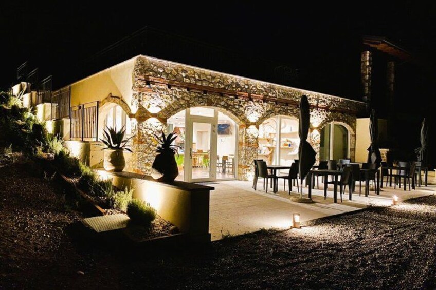 A stone building with outdoor seating and a well-lit entrance. 4