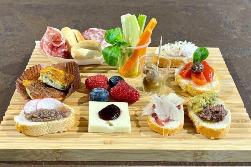 A wooden board with various food items including bread, cheese, and fruits. 1