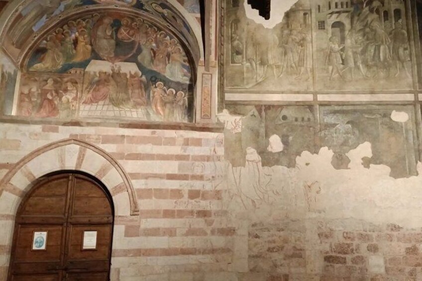 A brick wall with frescoes and a wooden door. 3