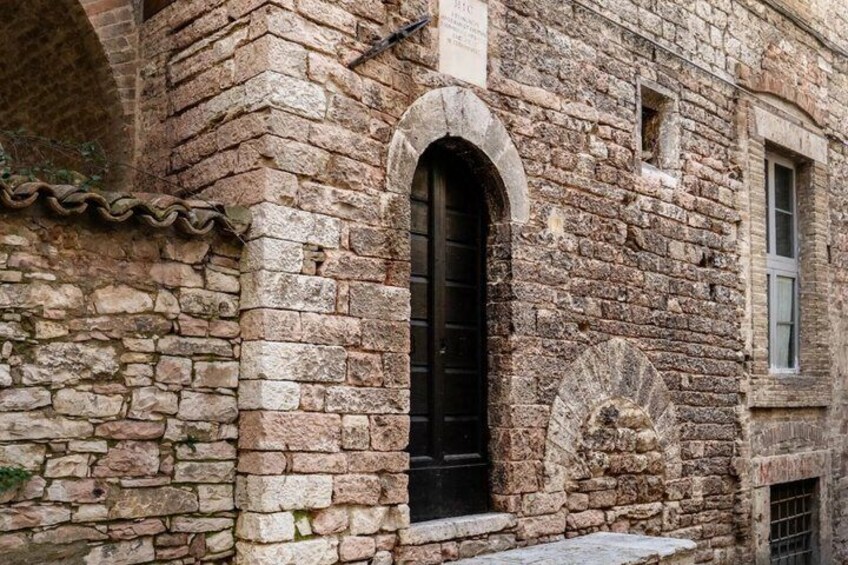 A stone building with a black door and arched windows. 4