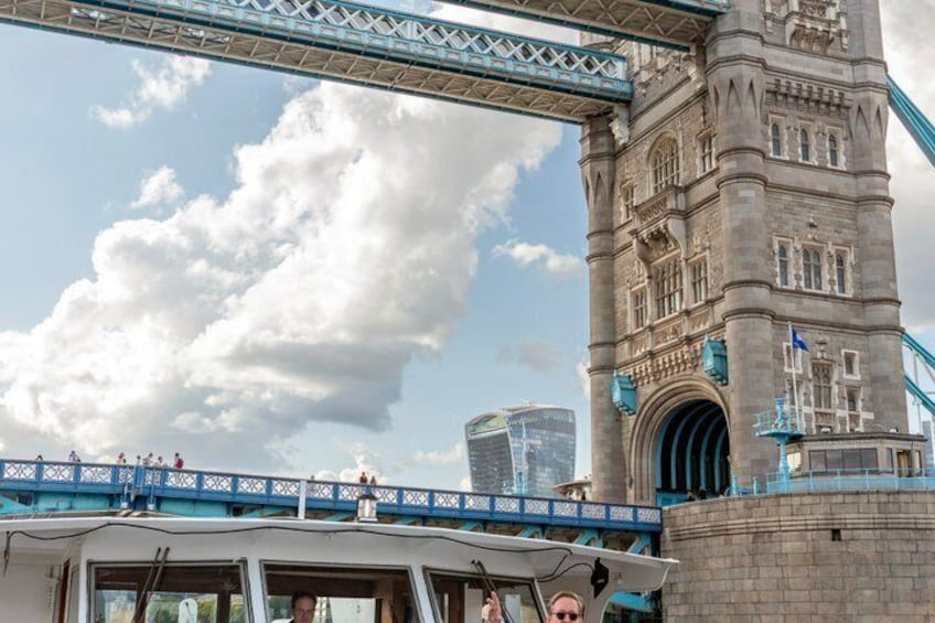 A bridge with a tower, a boat, and a modern building in the background. 4