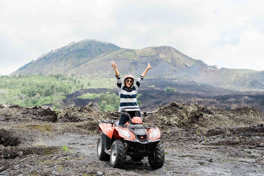 A person on an ATV with a mountainous landscape in the background. 3