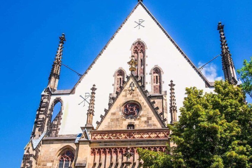 A church with a pointed roof, arched windows, and a clock. 5