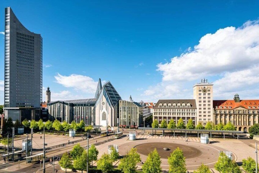 A city square with a roundabout, modern buildings, and a historic church. 1