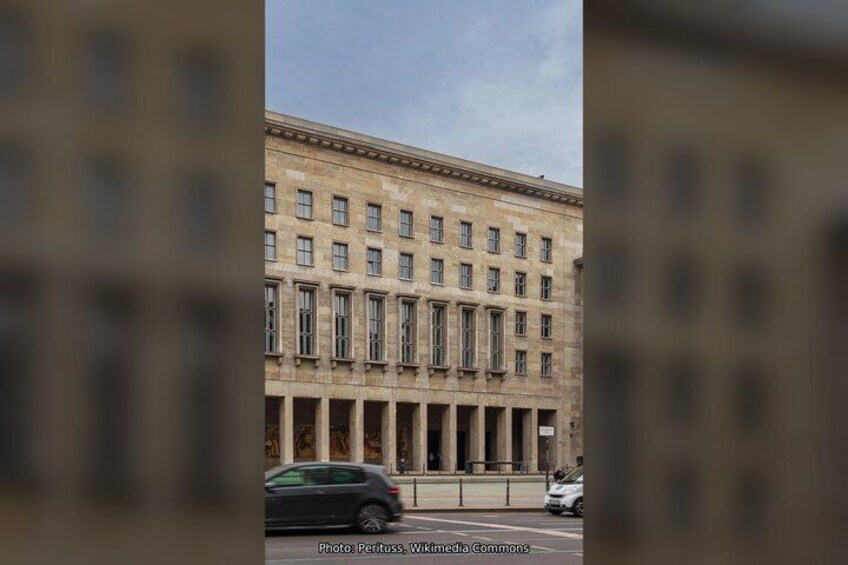 A large, historic building with a symmetrical facade, multiple windows, and a central entrance. 4
