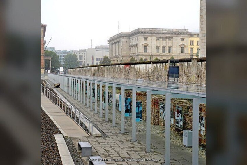 A pedestrian bridge with vertical supports and posters. 2