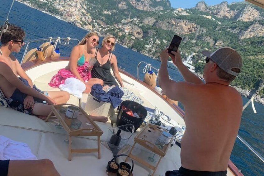 A group of people on a boat with rocky cliffs in the background. 3