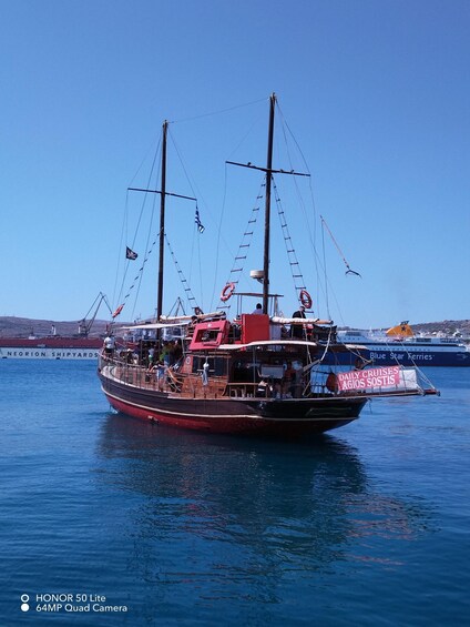 A traditional sailing ship docked at a harbor with a clear blue sky in the background. 2