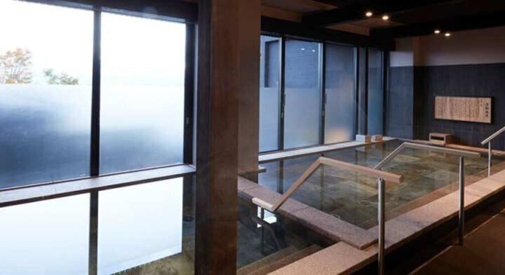 A modern indoor space with large windows, a glass table, and a wooden bench. 3