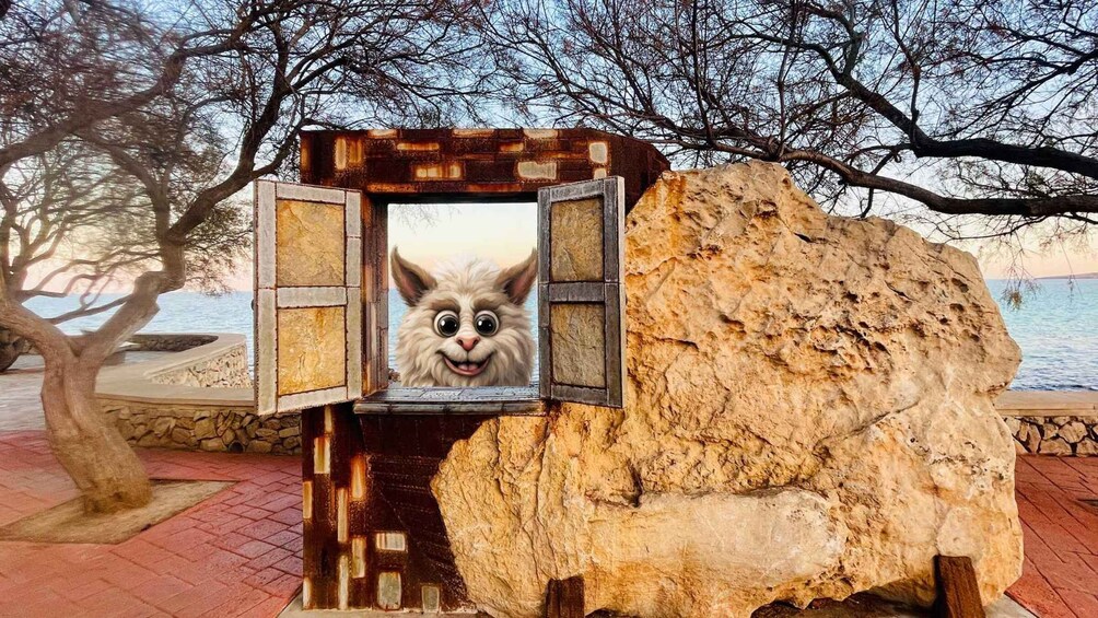 A rock with a window revealing a cat's face. 3