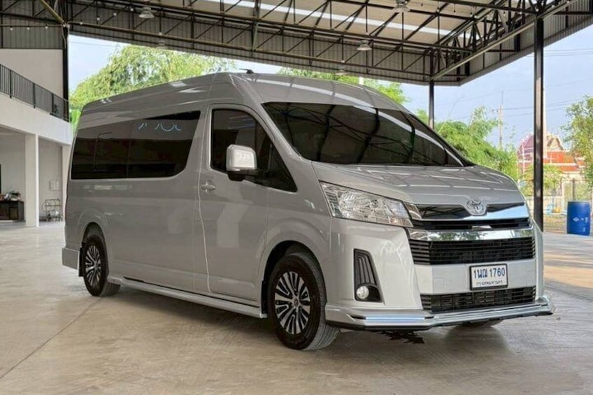 A silver van parked in a covered outdoor area with a metal roof structure. 5