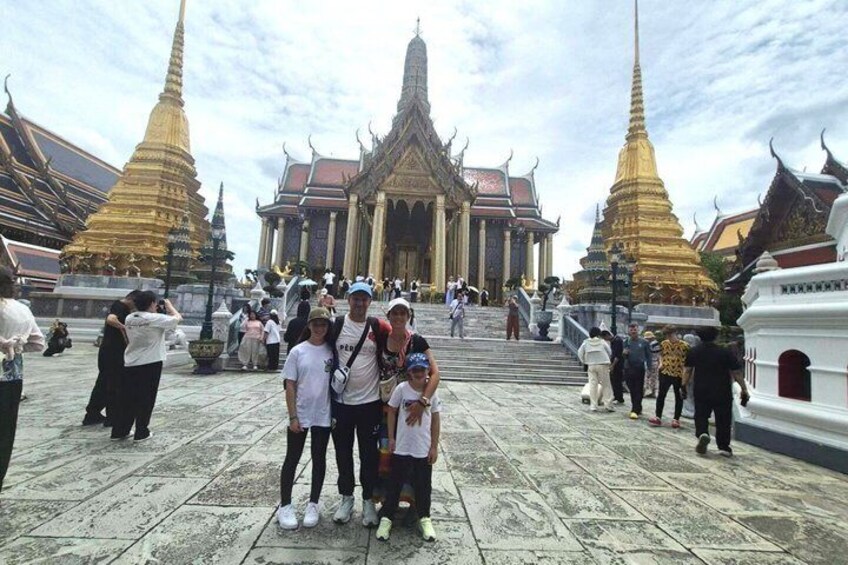 A group of people posing in front of a temple with golden spires. 2