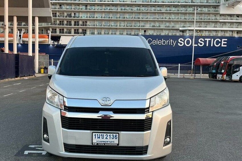 A white Toyota van parked in front of a building with a sign that reads 'Celebrity SOLSTICE'. 2