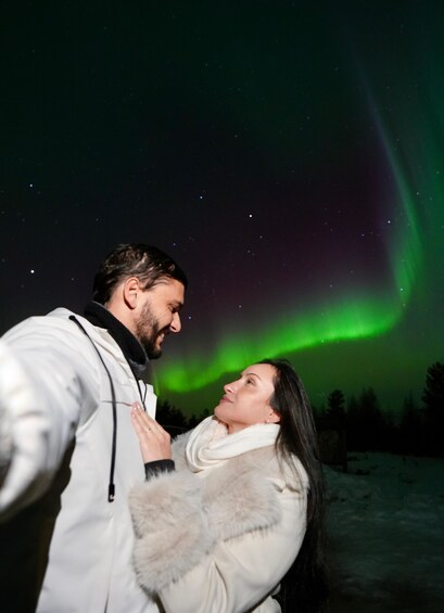 A couple embracing under a night sky with the aurora borealis. 5