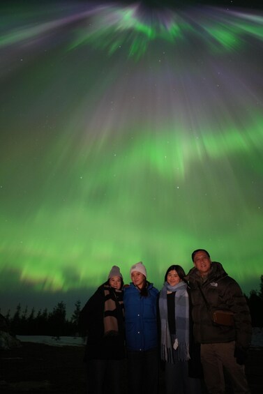 A group of people posing under the aurora borealis. 3