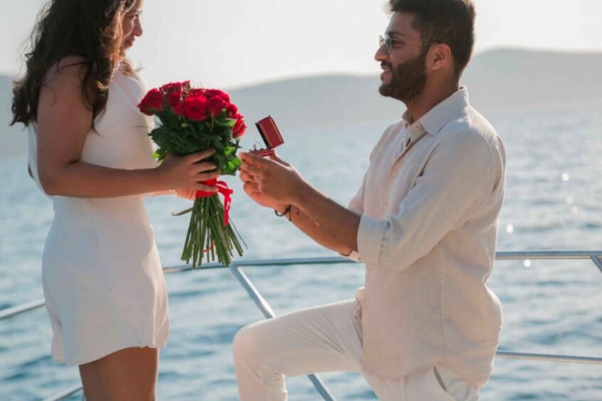 A person proposing to another with a bouquet of red roses on a boat. 1
