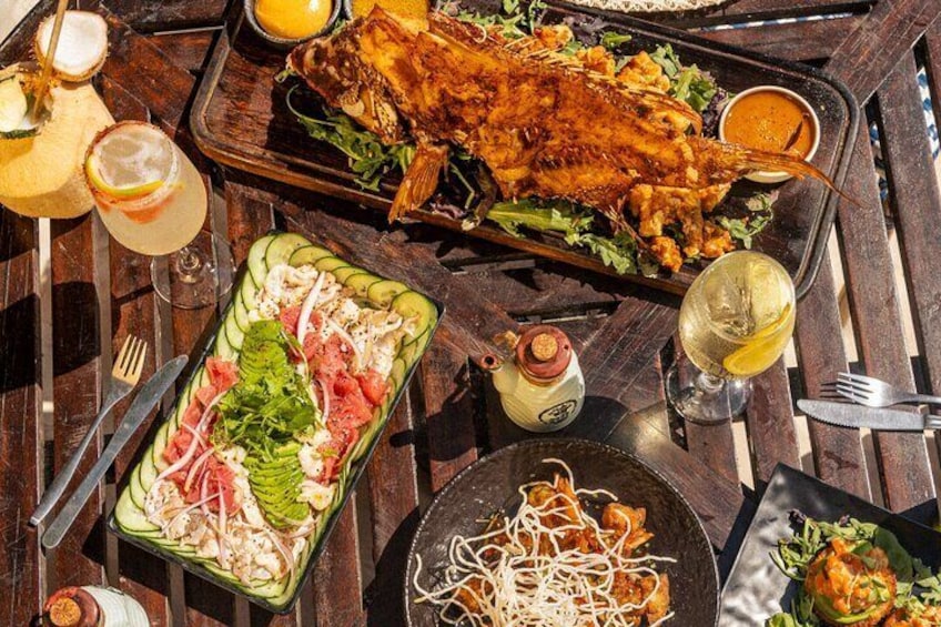 A variety of dishes including a whole roasted fish, a salad, and noodles. 4
