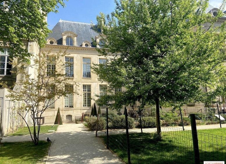 A historic building with a large tree in the foreground. 3