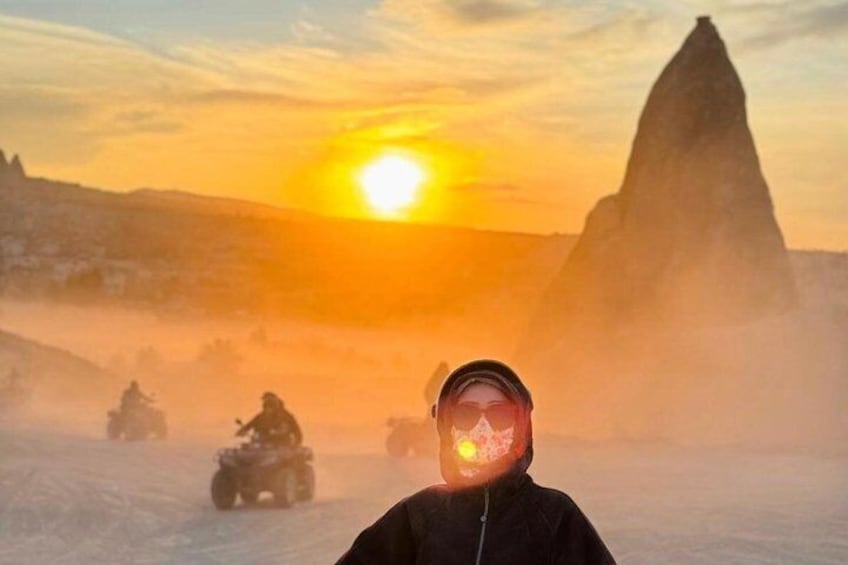 A person on a snowmobile with a sunset in the background. 3