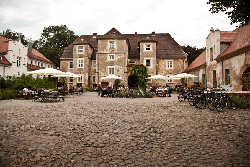 A cobblestone courtyard with outdoor seating and bicycles. 4